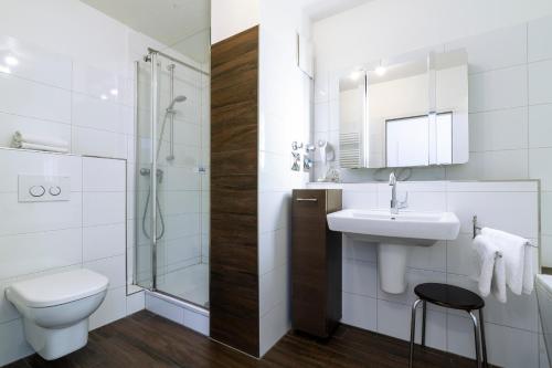 a bathroom with a toilet sink and a shower at Ferienwohnung Sandburg App 27a in Timmendorfer Strand