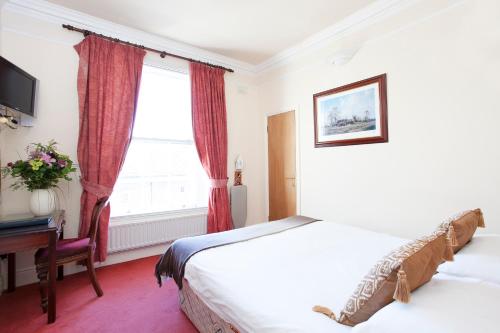 um quarto de hotel com duas camas e uma janela em The Leeson Lodge em Dublin