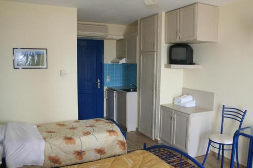 a living room with a couch and a small kitchen at Agnadi Hotel in Rovies
