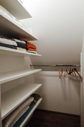 a walk in closet with white shelves and hangers at Vulkanland Stoeckel - Feldbach in Feldbach