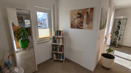 a room with a book shelf filled with books at Gästehaus Freystadt in Freystadt