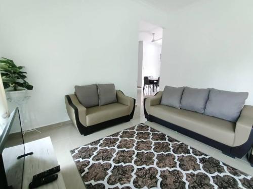 a living room with two couches and a rug at Homestay Kemaman Fyna07 Banglo Mewah 5 KM Dari Pantai Kijal in Kijal
