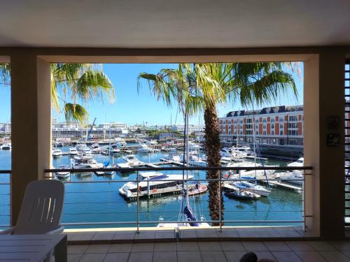 a room with a view of a marina with boats at African Elite Waterfront in Cape Town
