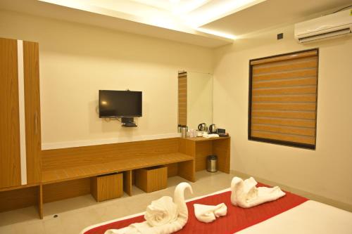 a hotel room with a tv and a red rug at Hotel 7-B in Chhatarpur