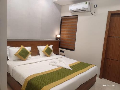 a hotel room with a bed with a towel on it at Hotel 7-B in Chhatarpur