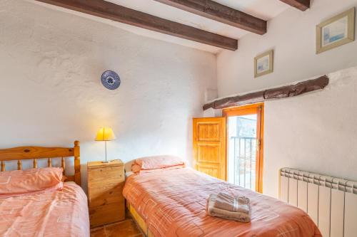 sypialnia z 2 łóżkami i oknem w obiekcie Casa Aitana-abdet -val de Guadalest w mieście Confrides