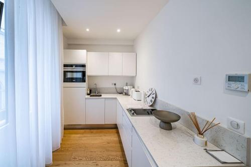 une cuisine avec des armoires blanches et un comptoir dans l'établissement Luxury Apartment 100 m to Palais des Festivals, à Cannes