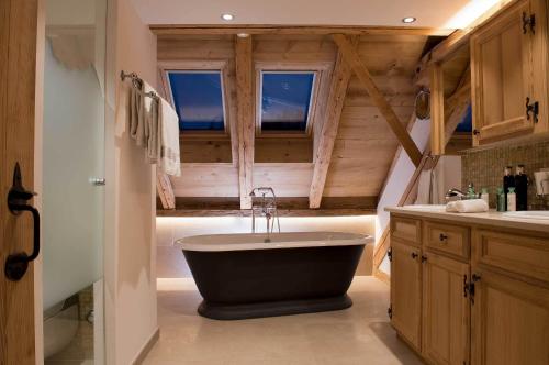 a bathroom with a large bath tub in a room at Hotel Olden in Gstaad