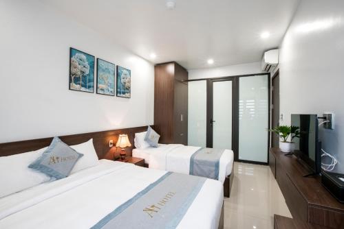 a hotel room with two beds and a flat screen tv at AUI Hotel 38 Máy Tơ in Ðoan Xá