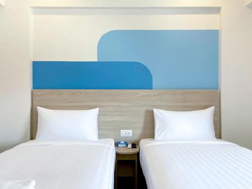 two beds sitting next to each other in a room at HOP INN Bangkok Krung Thonburi Station in Bangkok