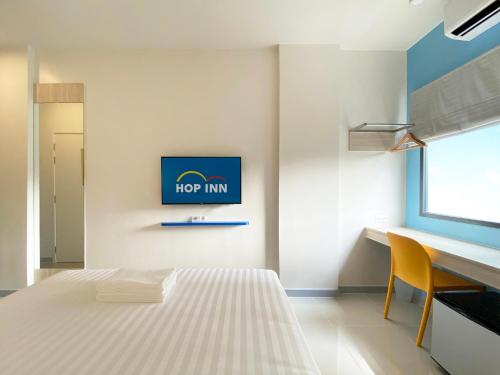 a bedroom with a hop inn sign on the wall at HOP INN Bangkok Krung Thonburi Station in Bangkok