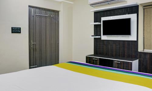 a bedroom with a white bed and a tv at Itsy Hotels Cradle Regency in Rānchī