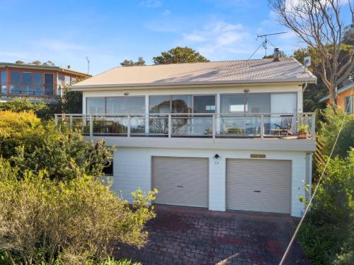 a white house with two garage doors and a balcony at Otway Views in Apollo Bay