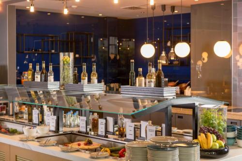 a buffet line with dishes and bottles of wine at Clayton Hotel Düsseldorf City Centre in Düsseldorf