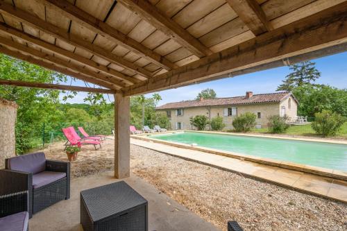 une terrasse avec une piscine et une maison dans l'établissement Villa spacieuse avec piscine privée, à Salies, 250 m², 6 chbres, à Saliès