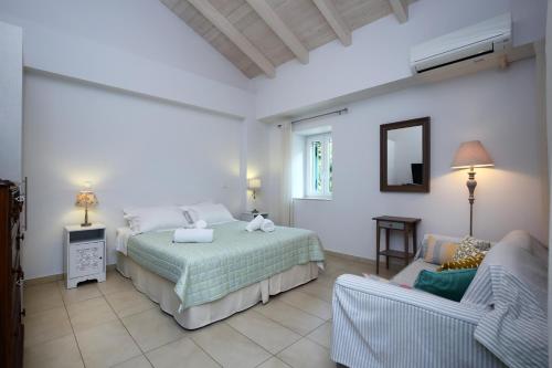 sypialnia z łóżkiem i krzesłem w obiekcie Wild Sea Apartments w mieście Agios Nikitas