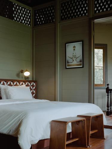 a bedroom with a large white bed and a window at neil niwas in Bangkok