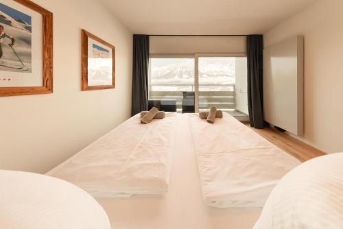 a large white bed in a room with a window at Apartment Alpenblick in Ellmau