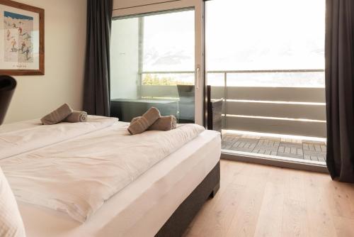 a bedroom with two beds and a large window at Apartment Alpenblick in Ellmau