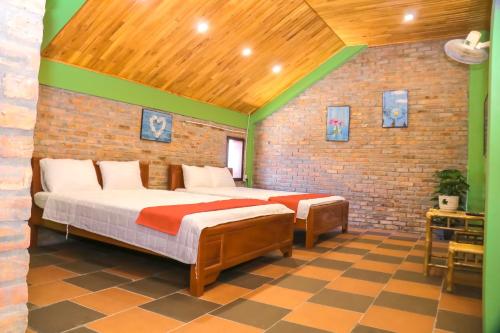 een slaapkamer met 2 bedden en een bakstenen muur bij Lucky Home in Hue