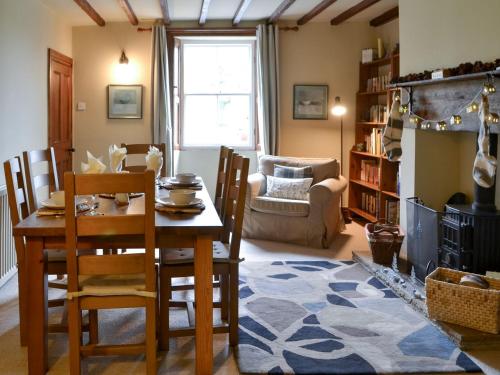 a living room with a table and chairs and a couch at Blue House Cottage in Elsdon