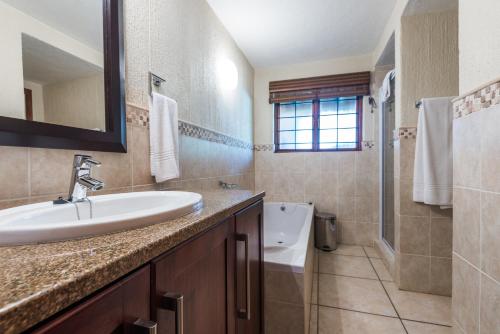 een badkamer met een wastafel, een toilet en een bad bij Kruger Park Lodge Unit No 521 with Private Pool in Hazyview