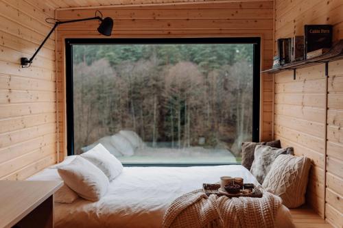 a bed in a room with a large window at Na skraju gaju in Purda