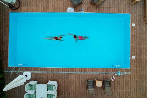 two people are swimming in a swimming pool at Sapanca View Hotel in Sapanca