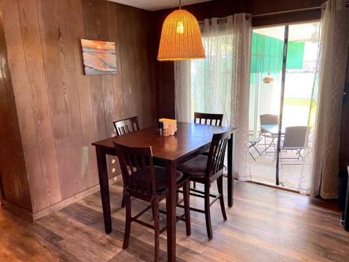 a wooden dining room table with chairs and a lamp at THE HILO HOMEBASE - Charming 3 Bedroom Hilo Home, with AC! in Hilo