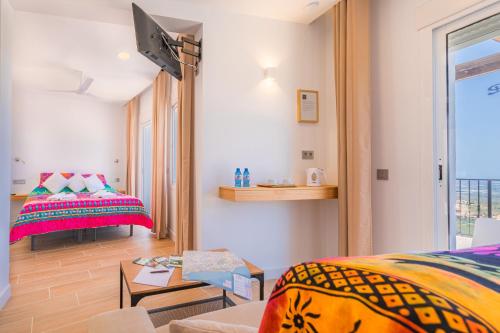 a room with a bed and a couch and a window at Casa Bédar in Bédar