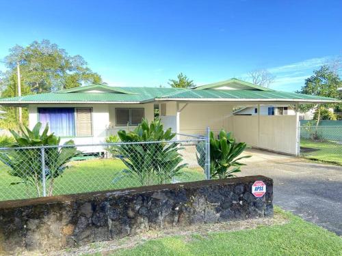 a house with a fence in front of it at THE HILO HOMEBASE - Charming 3 Bedroom Hilo Home, with AC! in Hilo