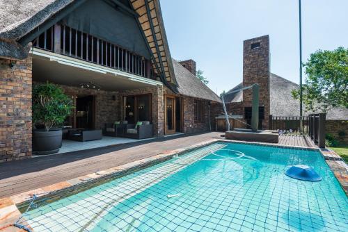a swimming pool in front of a house at Kruger Park Lodge Unit No 521 with Private Pool in Hazyview