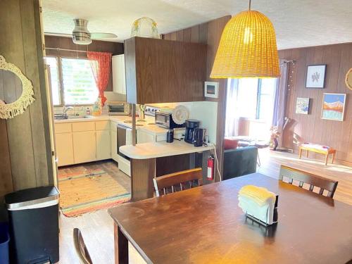 a kitchen with a table and a dining room at THE HILO HOMEBASE - Charming 3 Bedroom Hilo Home, with AC! in Hilo
