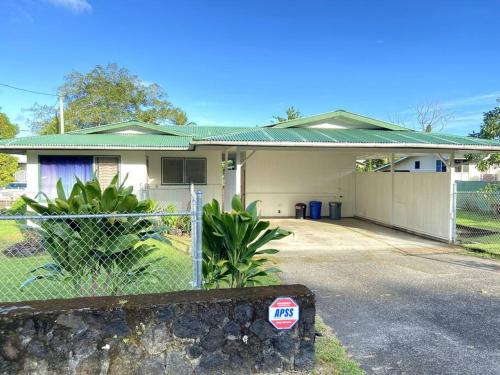 a house with a fence in front of it at THE HILO HOMEBASE - Charming 3 Bedroom Hilo Home, with AC! in Hilo