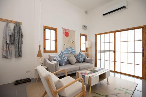 a living room with a couch and a table at Villa Sunrise Garden A180 in Thalang