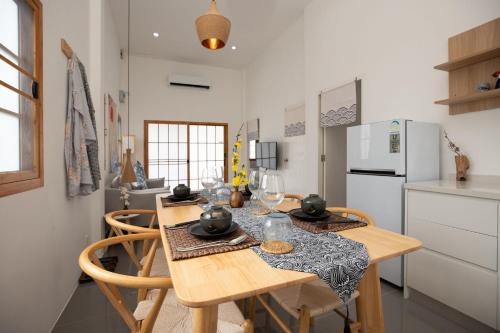 a kitchen with a wooden table and chairs in a kitchen at Villa Sunrise Garden A180 in Thalang