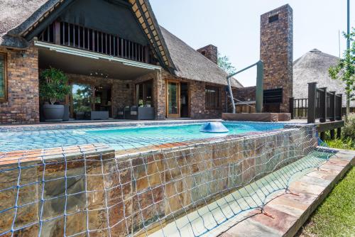 an outdoor swimming pool in front of a house at Kruger Park Lodge Unit No 521 with Private Pool in Hazyview