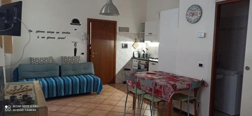 a kitchen and a living room with a table and a couch at porta merlonia house grazioso monolocale in Forlì