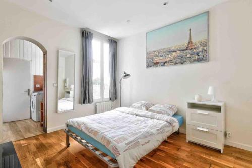ein Schlafzimmer mit einem Bett und einem Wandgemälde in der Unterkunft Lumineux & calme Studio à ivry sur seine in Ivry-sur-Seine