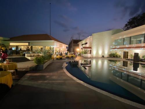 a hotel with a swimming pool at night at Mayur Belgaum Presidency Hotel & Spa in Belgaum