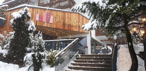 a snow covered building with stairs in front of it at La Roccia Wellness Hotel in Cavalese