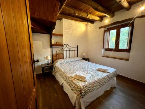 1 dormitorio con 1 cama en una habitación con ventana en Casa Barranco, en Júzcar