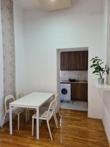 a dining room with a table and chairs and a kitchen at Feeling home in the heart of Budapest in Budapest