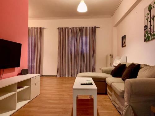 a living room with a couch and a table at 2 bedroom apartment 300 meters metro Aghios loanis in Athens
