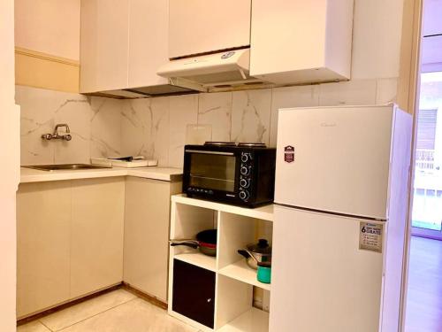 a kitchen with a white refrigerator and a microwave at 2 bedroom apartment 300 meters metro Aghios loanis in Athens
