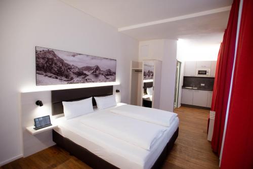 a bedroom with a large white bed in a room at Reos Hotel Wangen in Wangen im Allgäu