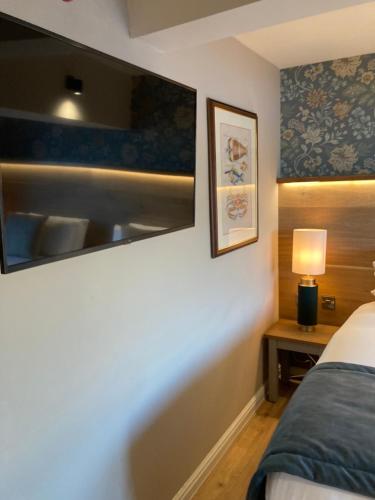 a bedroom with a bed and a lamp on a table at Duke of York in Whitby