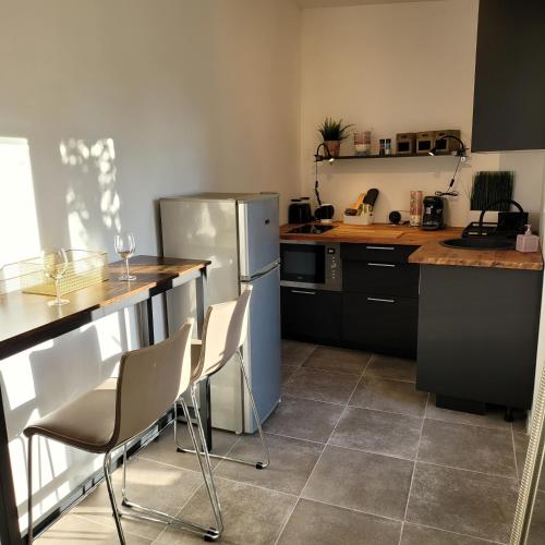 Il comprend une cuisine équipée d'un comptoir avec des chaises et d'un réfrigérateur. dans l'établissement LE MAZET, à Saint-Raphaël