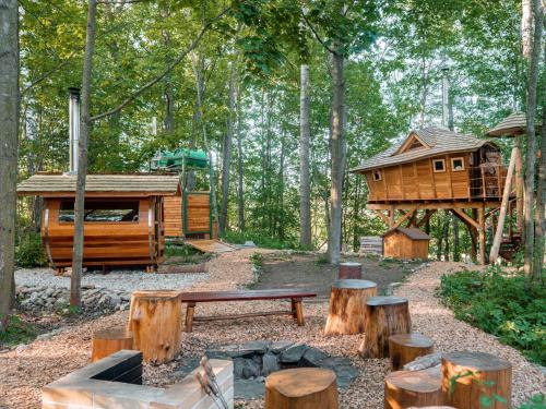 多尼蒙拉沃的住宿－Treehous Sněžník s wellness，树林里的树屋,有长凳和木头