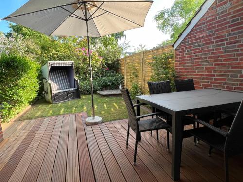 - une table avec un parasol sur une terrasse en bois dans l'établissement Appenzeller, S u A , Ferienhaus Dangaster Tied 1, à Dangast